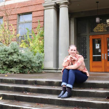 Alice Lulich sitting on the steps outside Kidder Hall. 