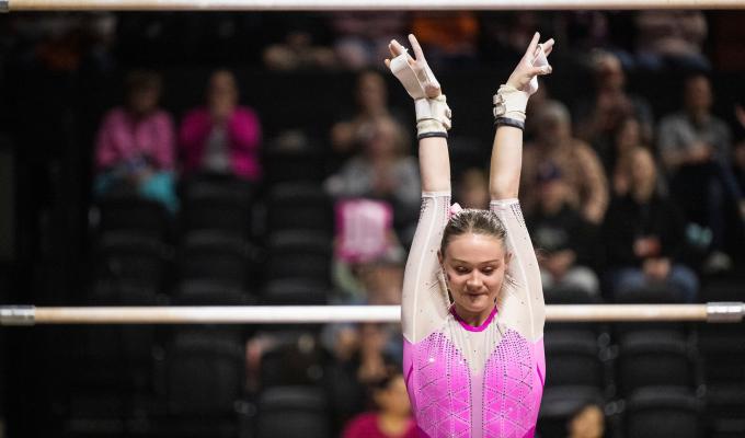 Carley Beeman stands in an OSU leotard after finishing a bar routine.