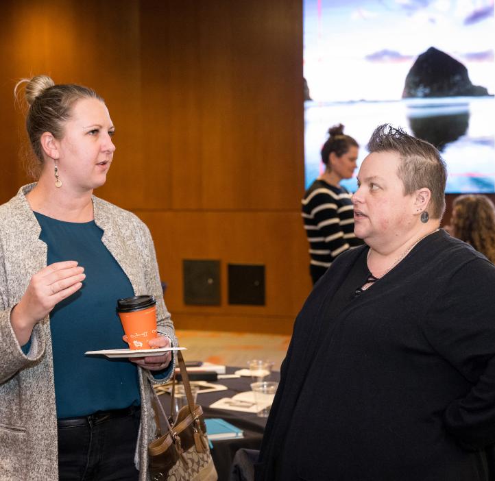 Two participants talk about interesting science topics at the Winter 2024 Awards Ceremony at Oregon State University.