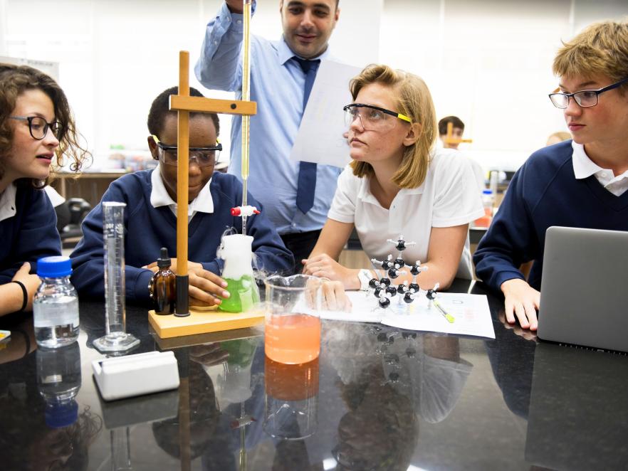 High school teacher teaching chemistry to students.